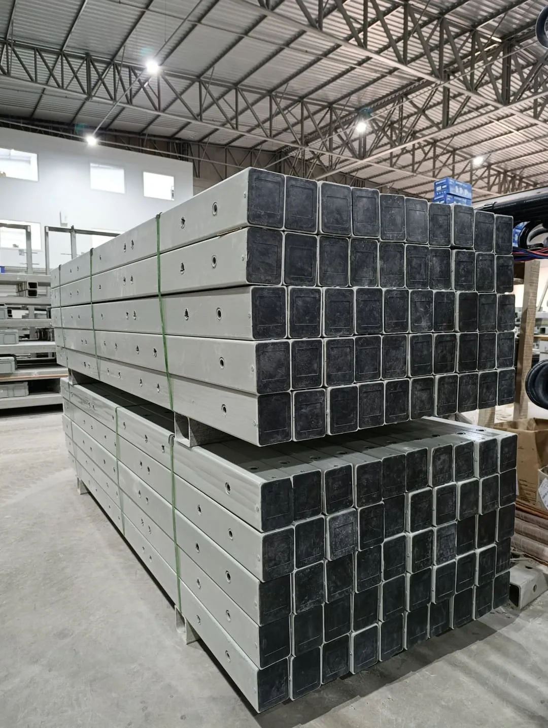 Cruzetas em PRFV IDP empilhadas na fábrica, prontas para envio às redes de distribuição de energia.